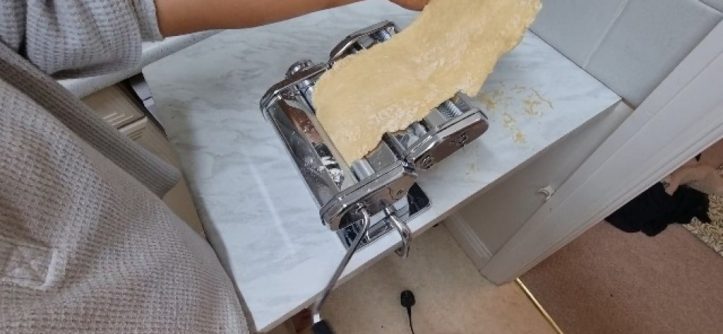 Busy mom smiling while Marcato AtlasMotor extrudes perfect golden spaghetti onto parchment paper