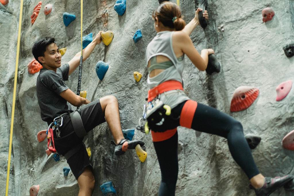 Climber mid-ascent on indoor gym wall, securely belayed with 10ft Faxco rope demonstrating flexibility and strength in action.