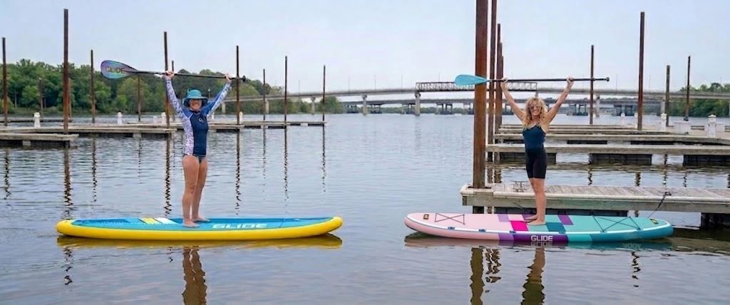 Beginner paddling an inflatable SUP board on calm water