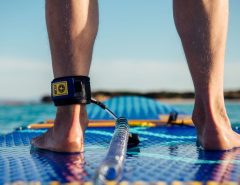 Inflatable stand up paddle board setup on beach with pump and gear