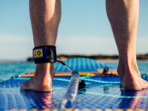 Inflatable stand up paddle board setup on beach with pump and gear