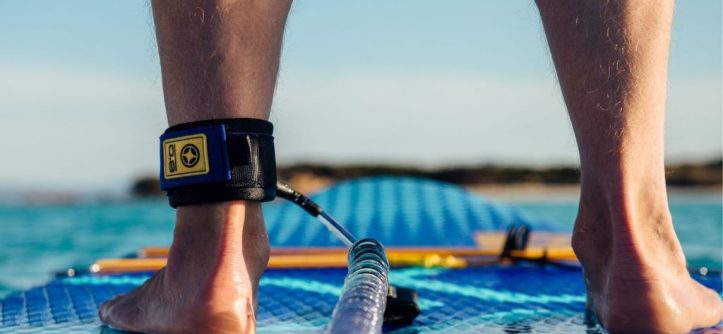Inflatable stand up paddle board setup on beach with pump and gear