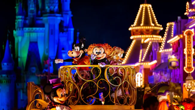 Villains and characters marching in the Boo-to-You parade at night