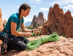 Climber examining a bright climbing rope on Colorado sandstone