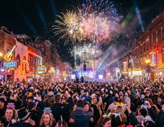 Crowds celebrating Nashville New Year's Eve on Broadway with fireworks lighting up the night sky