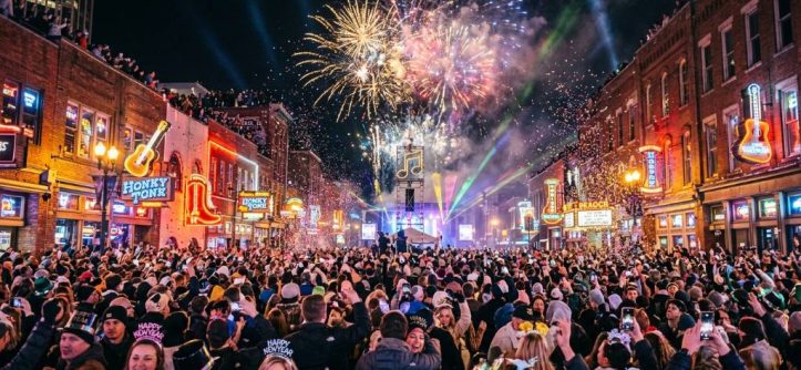 Crowds celebrating Nashville New Year's Eve on Broadway with fireworks lighting up the night sky