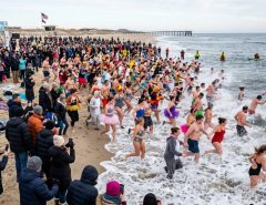 Crowds rushing into ocean waves during a New Year's Day polar bear plunge event in the United States